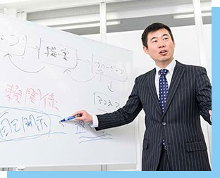 写真:ホワイトボードに向かって営業研修を指導